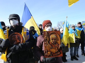 People hold wooden carvings of Ukrainian writer Taras Shevchenko as the Ukrainian community in Winnipeg held its third rally in as many weekends at the Manitoba Legislative Building on Sunday, March 13, 2022.
