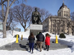 Mitglieder der Jugendgruppe legen einen Kranz an einem Denkmal für den ukrainischen Schriftsteller Taras Shevchenko nieder, als die ukrainische Gemeinde in Winnipeg am Sonntag, dem 13. März 2022, ihre dritte Kundgebung an ebenso vielen Wochenenden im Manitoba Legislative Building abhielt.