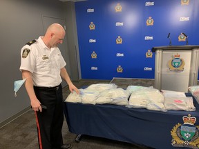 Insp. Elton Hall of the Winnipeg Police Organized Crime Unit at a press conference at Winnipeg Police Headquarters on Tuesday, points at a package of drugs on a set of tables loaded down with confiscated drugs and cash. In total, police seized 28 kilograms of methamphetamine with a street value of $1.4 million, three kilograms of fentanyl worth $560,000 and a kilo of cocaine with a street value of $80,000 in addition to a large amount of cash. Five men from Winnipeg, Edmonton and Surrey, B.C., were arrested and charged with drug trafficking and proceeds of crime-related offences.