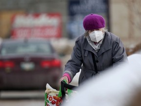 A person wears a mask while walking in a parking lot in Winnipeg on Tuesday, March 15, 2022.