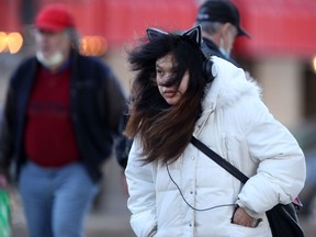 People crossing a street in downtown Winnipeg on Saturday, March 19, 2022.