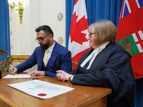 Obby Khan is sworn in by Patricia Chaychuk, clerk of the Legislative Assembly of Manitoba, as the newest MLA for the Manitoba PC Party, Monday morning at the Manitoba Legislative building. Having won the by-election for the Fort Whyte constituency he is the first Muslim elected to Manitoba's Assembly. Mike Deal/Pool