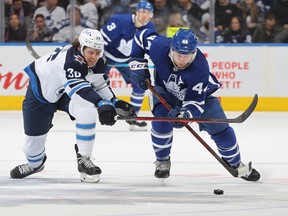 Morgan Barron (left)  chases down Maple Leafs defenceman Morgan Rielly on Thursday night at Scotiabank Arena. Barron made his Jets debut in the 7-3 loss.