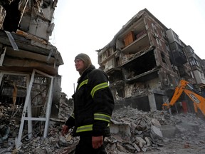 A rescuer works at a residential building damaged during Ukraine-Russia conflict in the southern port city of Mariupol, Ukraine April 19, 2022.