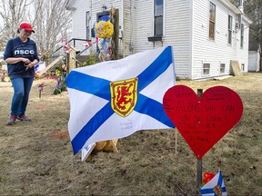 People pay their respects at a roadside memorial in Portapique, N.S. on Sunday, April 26, 2020.