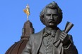 The Golden Boy is seen atop the Manitoba Legislative Building with the Louis Riel sculpture in the foreground in Winnipeg on Sunday, Nov. 21, 2021.