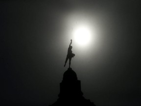 Thick blowing snow helps create a silhouette of the Golden Boy statue on the top of the Manitoba Legislative Building in Winnipeg.   Chris Procaylo,  Tuesday. January 18. 2022 Winnipeg Sun