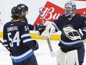 Winnipeg Jets goaltender Eric Comrie (right) is congratulated on his first NHL shutout, against the Philadelphia Flyers on Wednesday night.