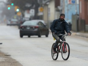 A person rides a bicycle on a street n Winnipeg on Saturday, April 30. The city will begin putting up reduced speed limit signs on certain streets for its enhanced bike program within the next three weeks.