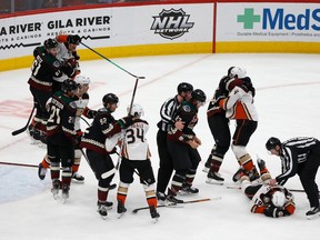Jay Beagle (83) of the Arizona Coyotes is held back by linesman Jonathan Deschamps after a fight with Troy Terry (19) of the Anaheim Ducks during the third period of the NHL game at Gila River Arena on April 1, 2022 in Glendale, Ariz. The Ducks defeated the Coyotes 5-0.