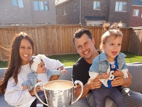 Quarterback Zach Collaros, wife Nicole, older daughter Sierra and younger daughter Capri with the Grey Cup in Aurora, Ont., Friday.
