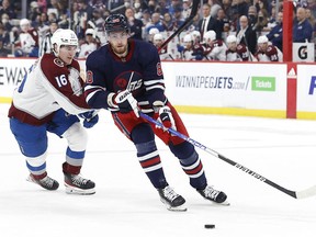 Winnipeg Jets left wing Pierre-Luc Dubois (80) is checked by Colorado Avalanche right wing Nicolas Aube-Kubel (16) in the first period at Canada Life Centre in Winnipeg on Friday, April 8, 2022.