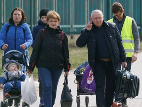 Ukrainian refugees walk after crossing the Ukraine-Poland border, amid the Russian invasion of Ukraine, in Medyka, Poland, April 7.