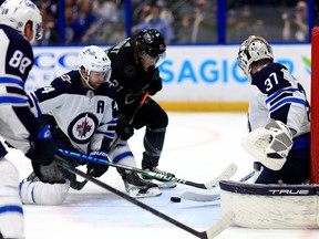 Connor Hellebuyck (37) of the Winnipeg Jets stops a shot from Brayden Point of the Tampa Bay Lightning in the second period during a game  at Amalie Arena on April 16, 2022 in Tampa, Fla.