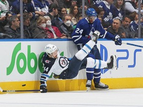 Josh Morrissey (44) of the Winnipeg Jets gets hammered by Wayne Simmonds (24) of the Toronto Maple Leafs during an NHL game at Scotiabank Arena on March 31, 2022 in Toronto.