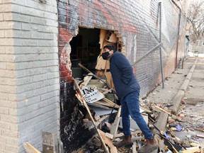 Owner Majid Chaudry looks at the damage to Pizzarama Chicken & Fries on Selkirk Avenue in Winnipeg on Sunday, April 10, 2022 after a vehicle fleeing police crashed into it on Saturday night. The 27-year-old driver died.