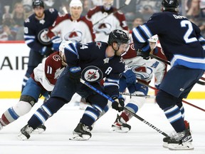 Winnipeg Jets defenceman Josh Morrissey (centre) straddles the Colorado Avalanche blueline with a defender in tow in Winnipeg on Sun., April 24, 2022.  KEVIN KING/Winnipeg Sun/Postmedia Network