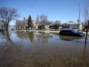 A vehicle surrounded by water on Webster Avenue in Winnipeg.  Chris Procaylo,  Wednesday. April 27. 2022 Winnipeg Sun