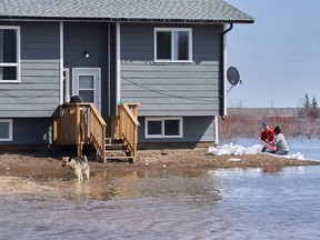 Rebecca Sutherland, of Pequis First Nation, and Shaine Paul from Red Rose volunteer to sandbag a home at risk of flooding in Peguis First Nation, Man., Wednesday, May 4, 2022.