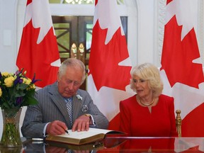 Prince Charles, Prince of Wales accompanied by Camilla, Duchess of Cornwall, signs a guest book at Canada House in London May 12, 2022.