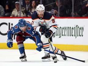 Connor McDavid (97) of the Edmonton Oilers looks for the puck against J.T. Compher (37) of the Colorado Avalanche in Game 1 of the Western Conference final of the 2022 Stanley Cup playoffs at Ball Arena on May 31, 2022, in Denver.