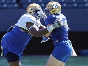 Adam Bighill (right) is blocked by Jermarcus Hardrick during Winnipeg Blue Bombers training camp on Tuesday, May 24, 2022.