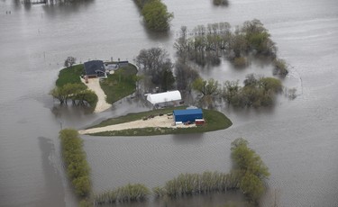 Properties just outside Winnipeg are isolated as a result of the Red River overflowing its banks south of Winnipeg, Sunday, May 15, 2022. John Woods/Pool/The Canadian Press