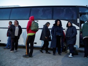 People, who were evacuated from Mariupol in the course of Ukraine-Russia conflict, stand outside a bus near a temporary accommodation centre in the village of Bezimenne in the Donetsk region, Ukraine May 7, 2022.