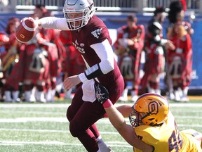 Ottawa Gee-Gees quarterback Sawyer Buettner escapes the grasp Queen's Golden Gaels Cameron Lawson at Richardson Stadium on Saturday, October 20 2018. The Bombers have acquired Lawson from the Als.  Ian MacAlpine/Postmedia Network file