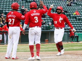 Winnipeg Goldeyes’ Eric Rivera (right) is welcomed at the plate by teammates Raul Navarro and Hidekel Gonzalez after hitting his first professional home run on May 15, 2022, during a 9-7 loss to the Fargo-Moorhead RedHawks 
at Shaw Park in Winnipeg.