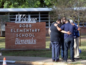 People gather at Robb Elementary School, the scene of a mass shooting in Uvalde, Texas, U.S. May 25, 2022.