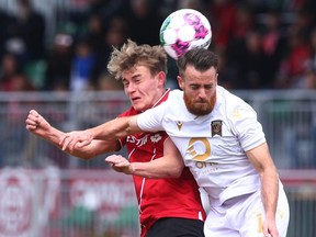 Cavalry FC Elliott Simmons and Valour FC Alessandro Riggi compete for a ball in the air during CPL soccer action between Cavalry FC and Valour FC at ATCO Field at Spruce Meadows in Calgary on Saturday. Jim Wells/Postmedia