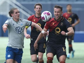 HFX Wanderers' Ryan Robinson (left) and Valour FC's Stefan Cebara contest a loose ball during Canadian Premier League  action in Winnipeg on Saturday, May 7.