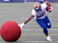 Running back Brady Oliveira stiff arms an obstacle during Winnipeg Blue Bombers training camp.