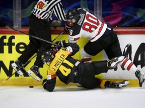 Germany's defender Jonas Muller (C) and Canada's forward Pierre-Luc Dubois (R) vie for the puck during the IIHF Ice Hockey World Championships group A match between Germany and Canada at the Helsinki ice Hall in Helsinki, Finland, on May 13, 2022.