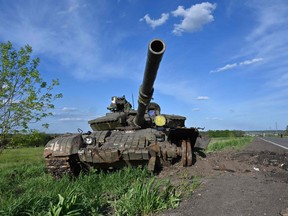 This photograph taken on May 13, 2022, shows a damaged tank on a road near the Vilkhivka village east of Kharkiv, amid Russian invasion of Ukraine.