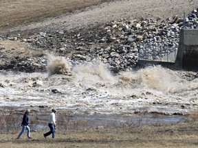 People walk by the churning waters at the Red River Floodway inlet structure in St. Norbert on Thurs., May 5, 2022.  KEVIN KING/Winnipeg Sun/Postmedia Network