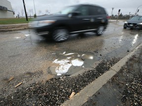 Vehicles dodge potholes filled with sandbags on De la Seigneurie Boulevard near Bishop Grandin Boulevard in St. Vital in Winnipeg on Mon., May 9, 2022.  KEVIN KING/Winnipeg Sun/Postmedia Network