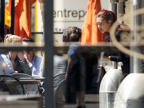 A server helping a table is pictured through plexiglass at Browns Socialhouse on Portage Avenue in Winnipeg on Tues., May 10, 2022. The Manitoba Restaurant and Foodservices Association will provide working capital grants to eligible businesses in the industry to help with recruitment initiatives, the province announced.  KEVIN KING/Winnipeg Sun/Postmedia Network