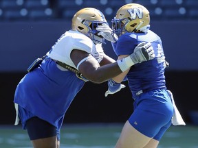 Adam Bighill (right) is blocked by Jermarcus Hardrick during Winnipeg Blue Bombers training camp on Tuesday, May 24, 2022.