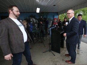 Coun. Scott Gillingham (centre), a mayoral candidate, looks at campaign manager Luc Lewandoski as he exits the podium after a press conference in which he was endorsed by Coun. Jeff Browaty (right) in Winnipeg on Monday, May 30, 2022.