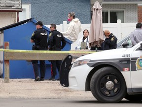 Forensics officers concentrate on an apartment garbage bin as police investigate a homicide after human remains were found in the 200 block of Edison Avenue in Winnipeg on Monday, May 16, 2022.