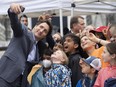 Prime Minister Justin Trudeau takes a photo with students visiting Parliament Hill during a Pride flag-raising ceremony on Parliament Hill, June 1, 2022 in Ottawa.