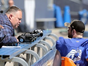 Wade Miller (left), the Winnipeg Blue Bombers president/CEO, speaks with long snapper Mike Benson, a player representative, during training camp.