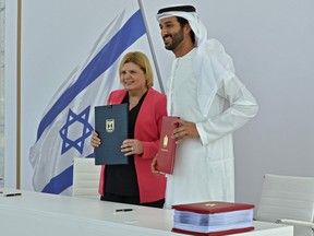 A handout picture obtained from the Israeli Government Press Office (GPO) on May 31, 2022, shows the economy ministers of Israel and the UAE Orna Barbivai and Abdulla bin Touq al-Marri posing for a photo during a signing ceremony for a free trade deal between Israel and the UAE, in Dubai.