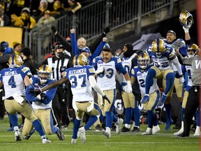 innipeg Blue Bombers players react as linebacker Kyrie Wilson (second from left) holds the ball after making an interception in overtime to clinch the victory over the Hamilton Tiger-Cats in the 108th Grey Cup football game at Tim Hortons Field.