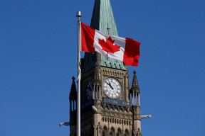 A Canadian flag in front of the Peace Tower on Parliament Hill in Ottawa.