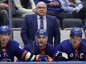 FILE - New York Islanders head coach Barry Trotz, top, looks on in the third period of an NHL hockey game against the Minnesota Wild, Jan. 30, 2022, in Elmont, N.Y. A Winnipeg brewery says it will give Trotz free beer for life if he returns to his native province to coach the Jets.