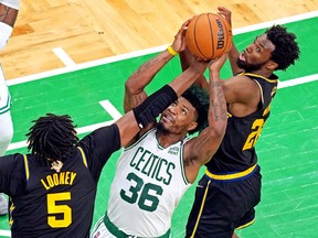 Boston Celtics guard Marcus Smart (36) goes for the ball against Golden State Warriors centre Kevon Looney (5) and forward Andrew Wiggins (22) during Game 4 of the NBA Finals at TD Garden.