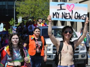 Eine Person trägt am Sonntag, den 5. Juni 2022, ein Schild bei der Pride Winnipeg-Parade durch die Innenstadt.